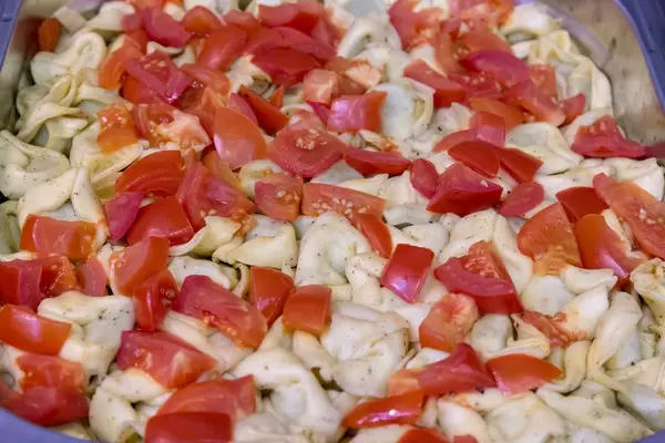 Spinattortellini mit Tomatenstücken in Käsesauce, im Wärmebehälter am Büfett