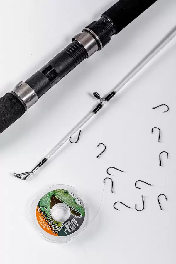 Spinning, hooks and fishing line on white background
