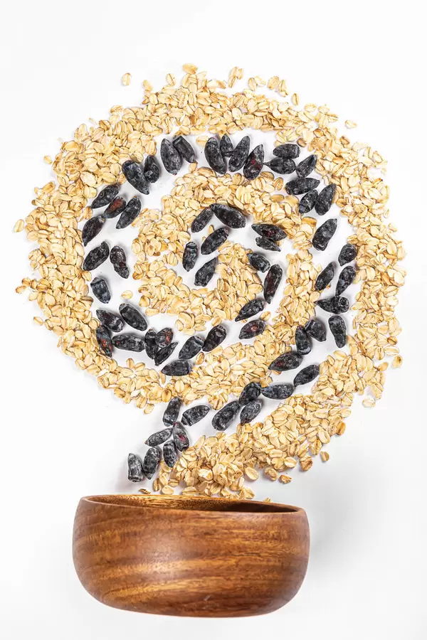 Spiral with oatmeal and honeysuckle berries with a wooden bowl, diet food