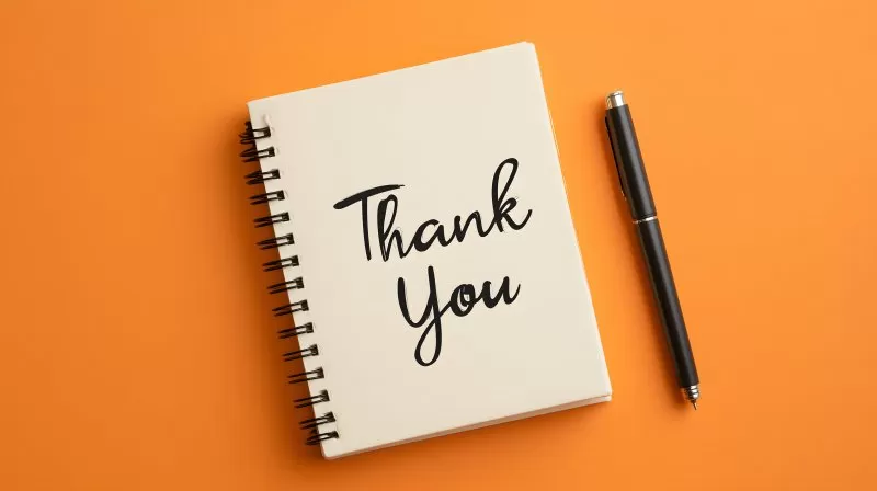 Spiralblock mit Thank You Aufschrift und Stift auf Orange