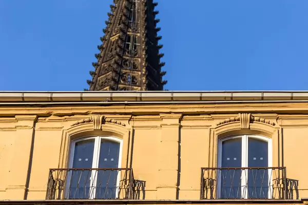 Spire of the Cologne Cathedral with a building in the foreground