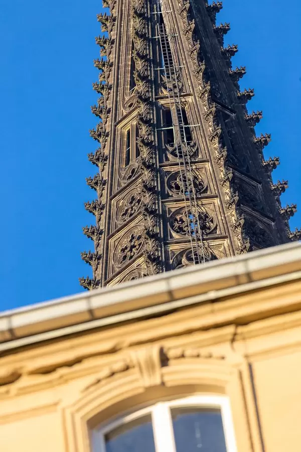 Spitze des Kölner Doms mit einem Gebäude im Vordergrund