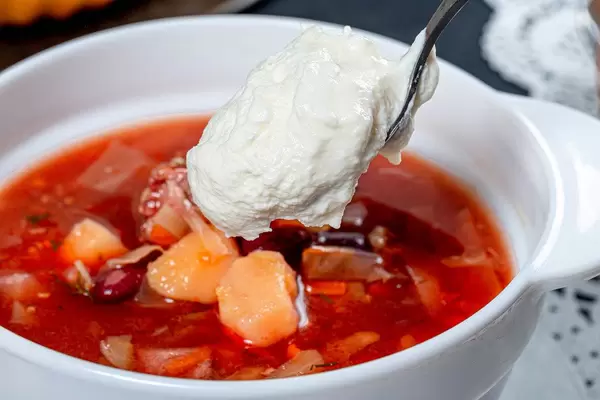 Spoon the sour cream put into a bowl of borscht close up (Flip 2019)