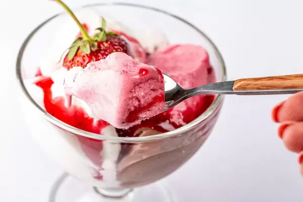 Spoon with ice cream in hand close-up