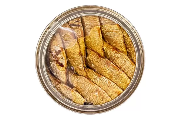 Sprats fish in a metal jar on a white background, top view