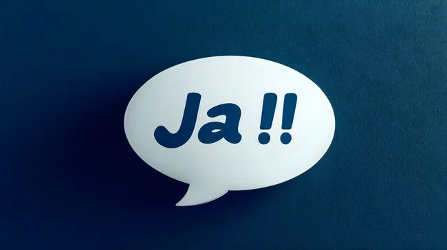 Sprechblase mit der Aufschrift 'Ja!!' auf blauem Hintergrund