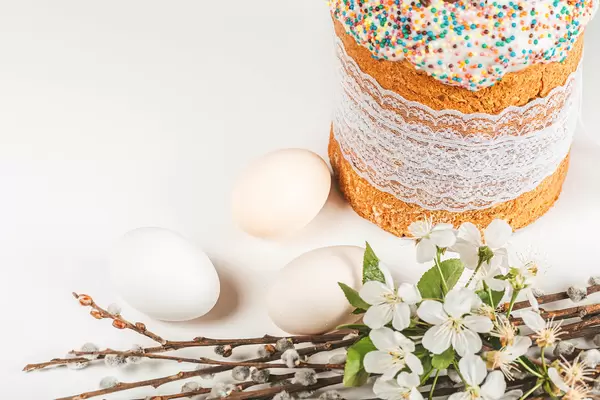 Spring branches of cherries and willows with easter cake and eggs