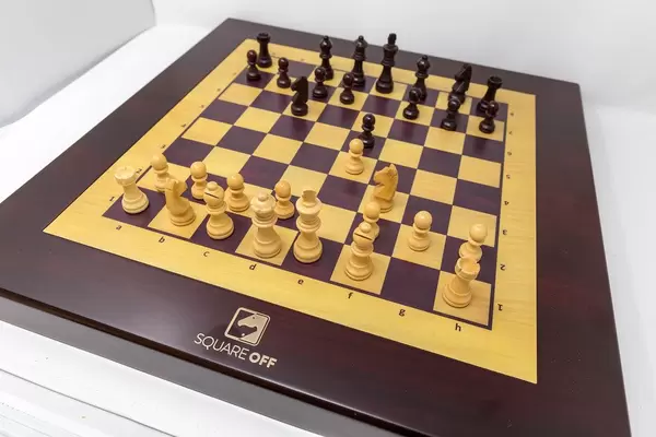Square Off Schachbrett mit Computergegner, über das Smartphone steuerbar, im Holzdesign mit angreifendem Pferd und Bauern, auf weißem Untergrund