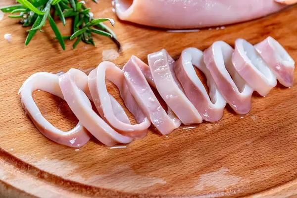 Squid rings boiled on wooden background