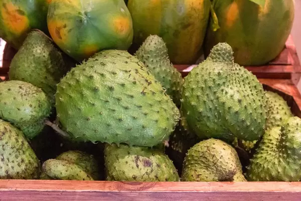 Stachelannone und Mango-Früchte in Holzkisten