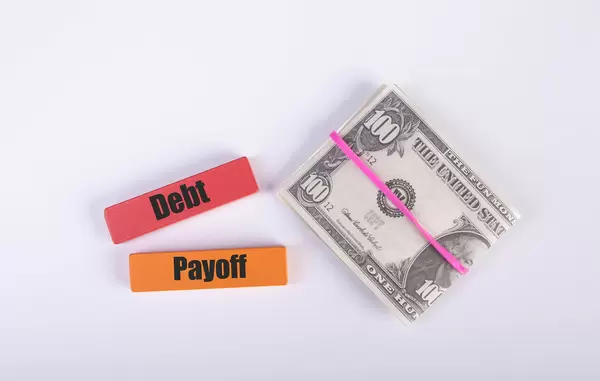 Stack of cash with Debt and Payoff text