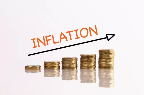 Stack of gold coins with arrow and inflation text