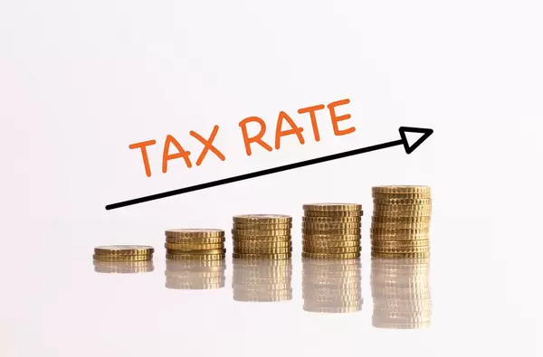 Stack of gold coins with arrow and tax rate text