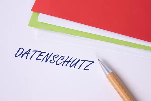 Stack of papers with pen and Datenschutz text