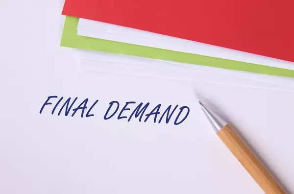 Stack of papers with pen and Final Demand text
