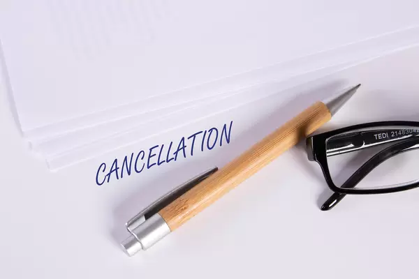 Stack of papers with pen, glasses and Cancellation text