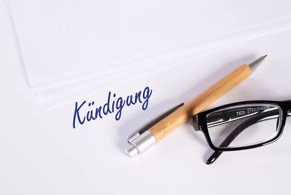 Stack of papers with pen, glasses and Kündigung text