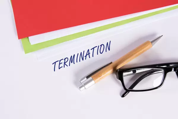 Stack of papers with pen, glasses and Termination text