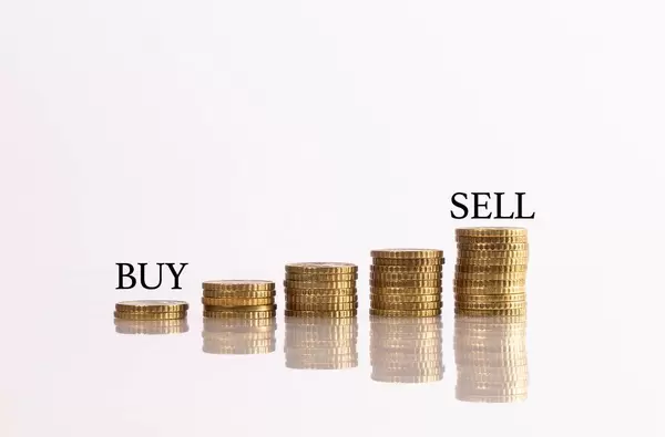 Stacks of coins with buy and sell text