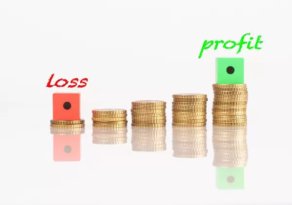 Stacks of coins with loss and profit text