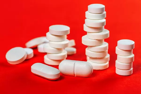Stacks of white pills on a red background