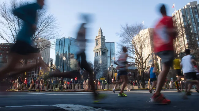 Stadtbild mit Marathonläufern und historischem Turm