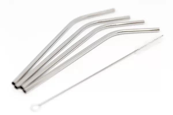 Stahl-Strohhalme und Reinigungsbürste vor weißem Hintergrund