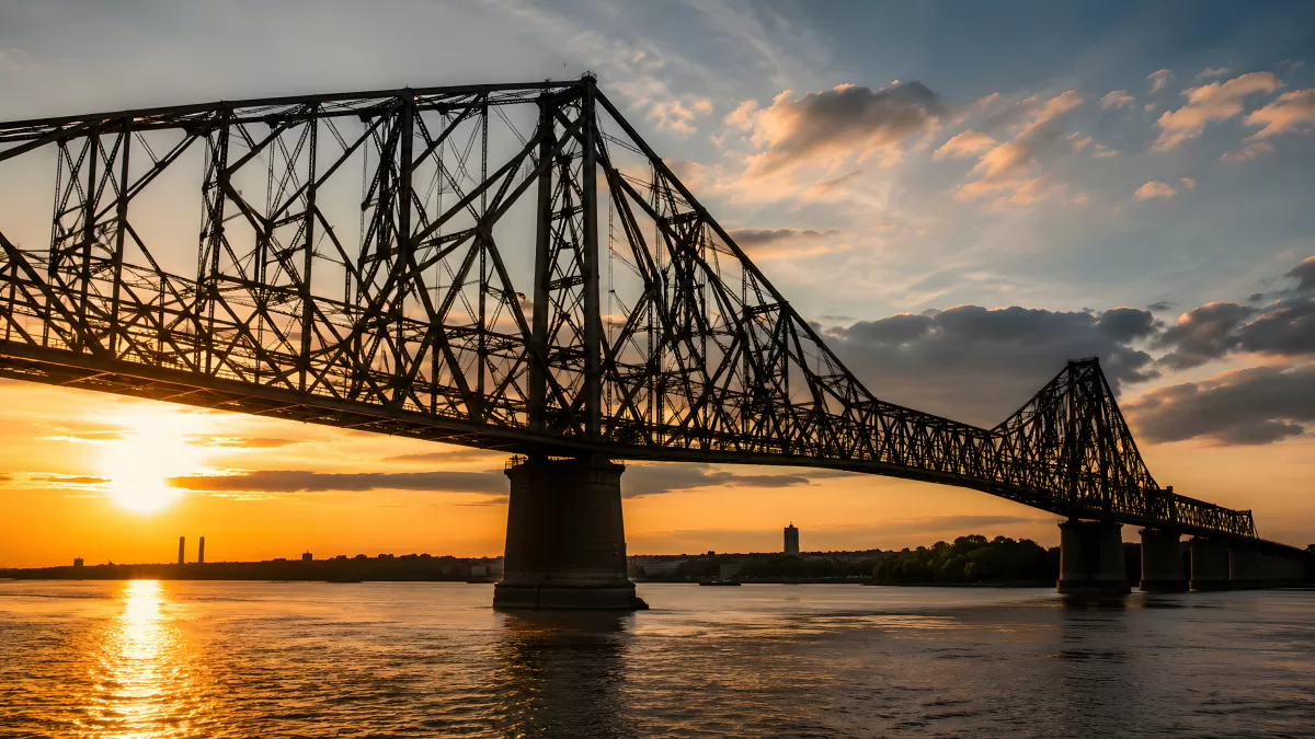 Stahlbrücke im Sonnenuntergang über ruhigem Fluss