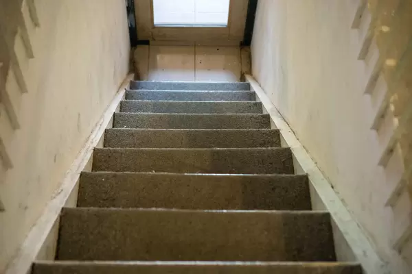Stairs from first Floor to Ground Floor in an Old Building without Handrail leading to a Door