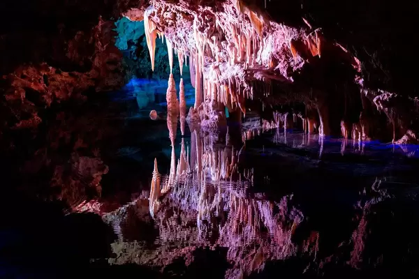 Stalactites reflect in the water of the underground lake known as the Sea of Venice, Cuevas del Hams