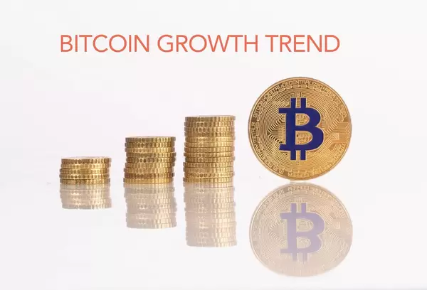 Stapel aus Goldmünzen mit goldener Bitcoinmünze und dem Text "Bitcoin Growth Trend" (Bitcoin Wachstumstrend)