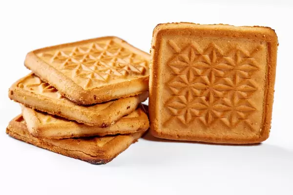 Stapel von quadratischen Butterkeksen isoliert vor weißem Hintergrund
