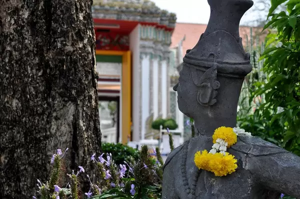 Statue mit Blumen über der Schulter in der Nähe des Tempels Wat Po