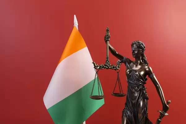 Statue of Lady Justice and flag of Ireland on red background