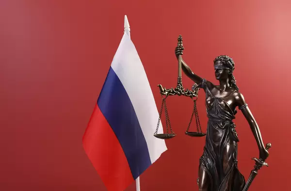 Statue of Lady Justice and flag of Russia on red background