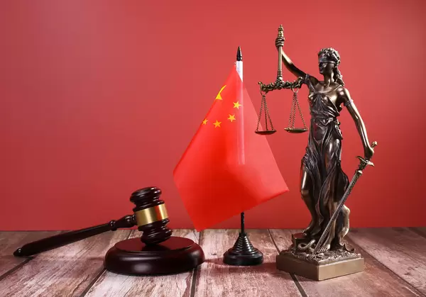 Statue of Lady Justice with Judge gavel and flag of China