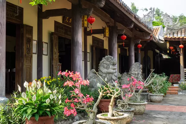 Statuen von Chinesischen Wächterlöwen und Blumentöpfe mit Bäumen und Pflanzen vor der Tam Ton Pagode bei den Marble Mountains in Da Nang, Vietnam