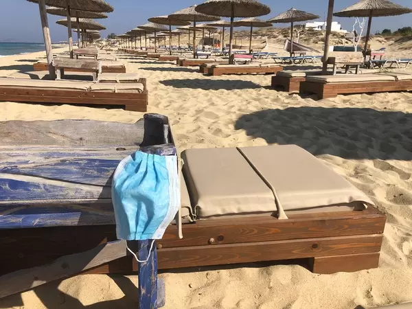 Staying safe and healthy during Corona vacation: face mask on a beach chair at Maragkas beach in Naxos, Greece