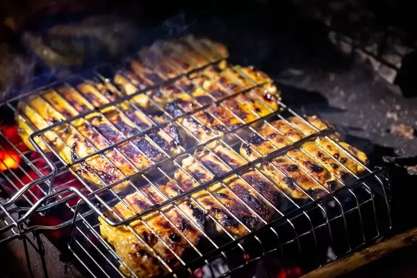 Steak on the grill with flames.