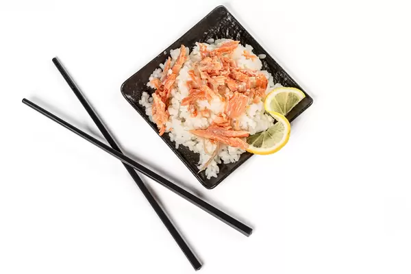 Steamed rice with salmon fillet and lemon, top view