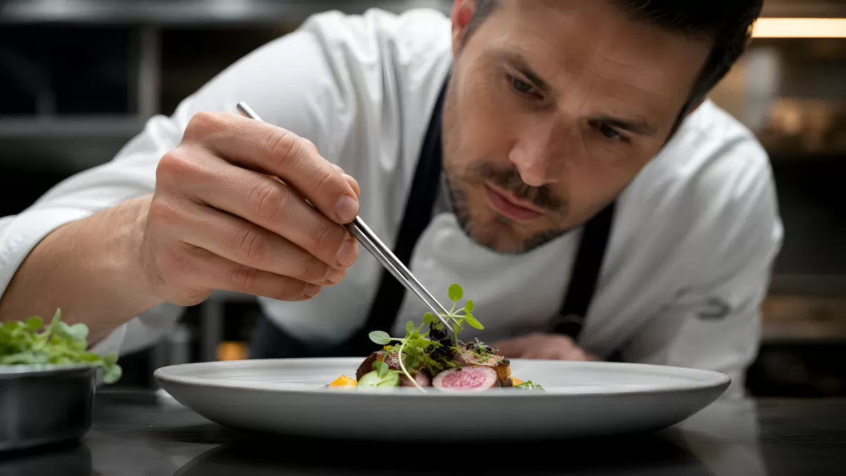 Sternekoch garniert ein Gourmetgericht mit Pinzette