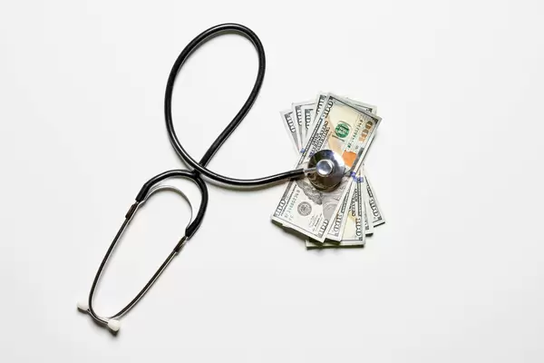 Stethoscope and money on white