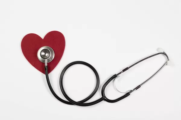 Stethoscope and red heart on white background
