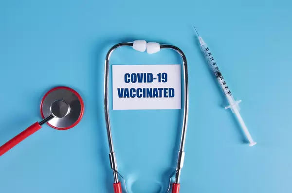 Stethoscope and syringe with Covid-19 vaccinated text