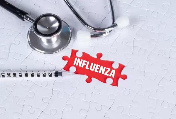 Stethoscope, syringe and missing puzzle with a influenza text