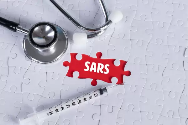 Stethoscope, syringe and missing puzzle with a SARS text