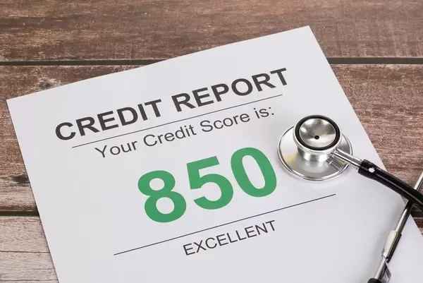 Stethoskop und Dokument mit ausgezeichnetem Kreditscore-Ergebnis von 850 auf einem Holztisch