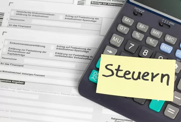 Steuern mit einem Taschenrechner auf einem Steuererklärungsformular