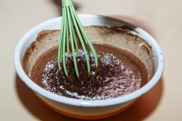 Stirring chocolate pastry for fondant cake