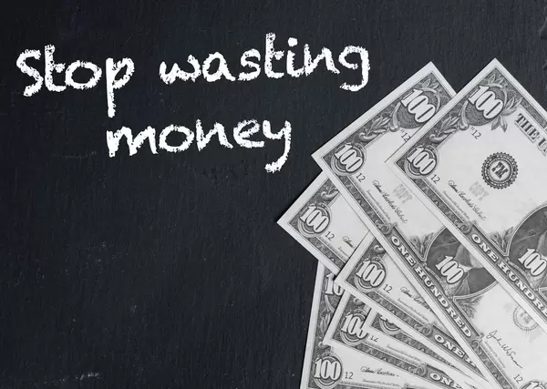 Stop wasting money text with US dollar banknotes